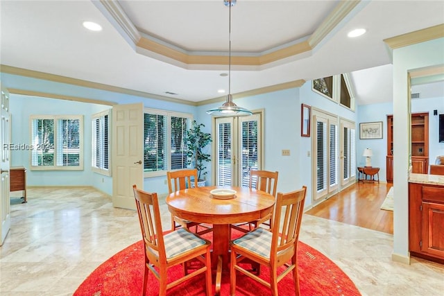 dining room with a tray ceiling, plenty of natural light, ornamental molding, and french doors