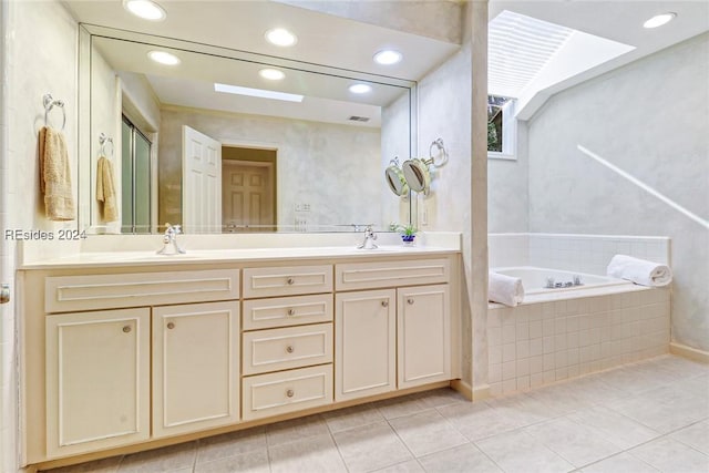 bathroom with tile patterned flooring, vanity, and a relaxing tiled tub