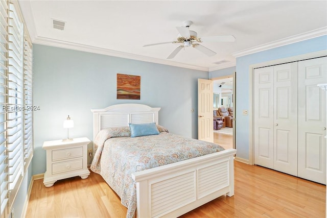 bedroom with light hardwood / wood-style floors, ornamental molding, a closet, and ceiling fan