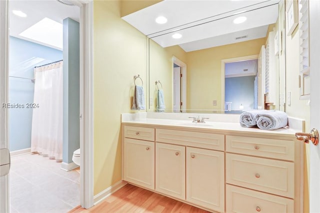 bathroom featuring vanity, wood-type flooring, toilet, and a shower with shower curtain