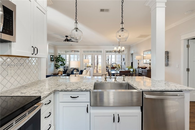 kitchen with stainless steel appliances, white cabinetry, sink, and pendant lighting