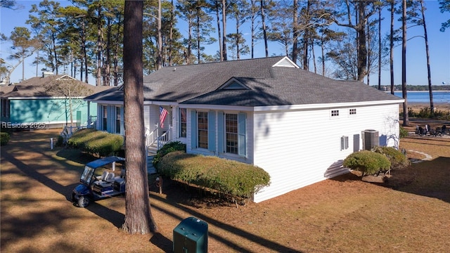 view of property exterior with central air condition unit and a water view