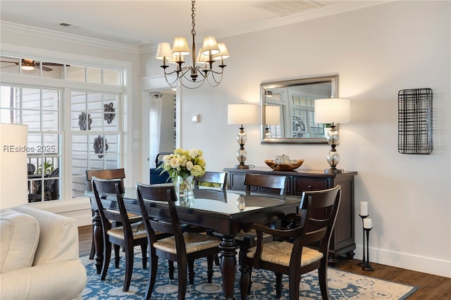 dining area featuring dark hardwood / wood-style flooring, crown molding, and ceiling fan with notable chandelier