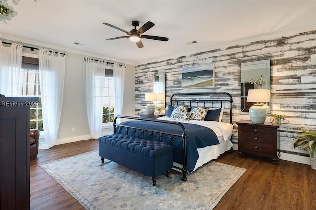 bedroom with crown molding, dark wood-type flooring, and ceiling fan