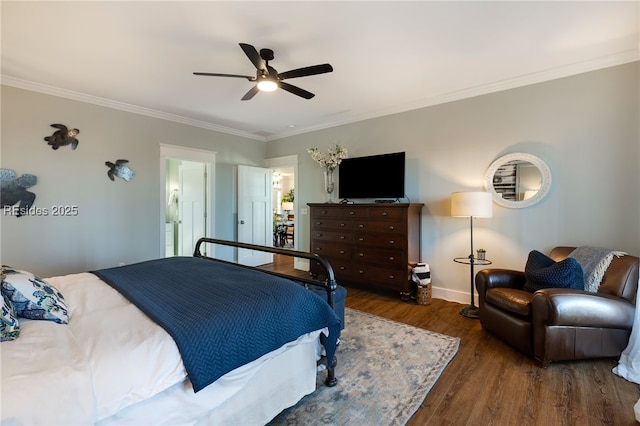 bedroom with crown molding, dark wood-type flooring, ensuite bathroom, and ceiling fan