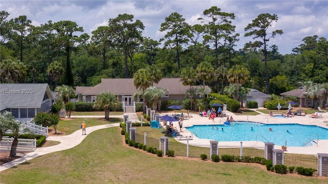 view of swimming pool featuring a patio and a lawn