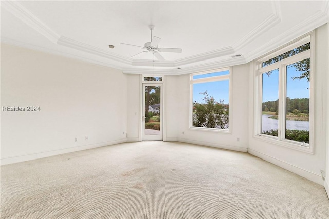 unfurnished room featuring light carpet, crown molding, a raised ceiling, and ceiling fan