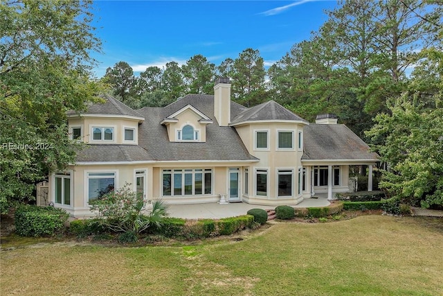 back of property with a yard and a patio area