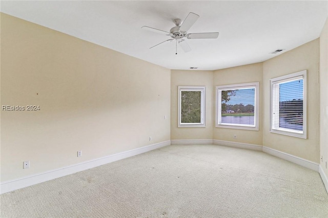 carpeted spare room featuring ceiling fan