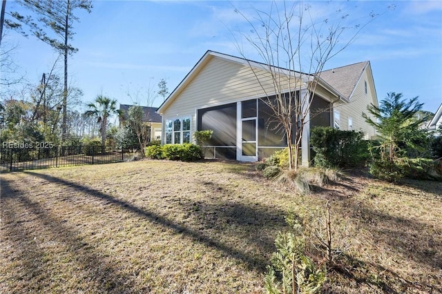 view of home's exterior featuring a sunroom and a lawn