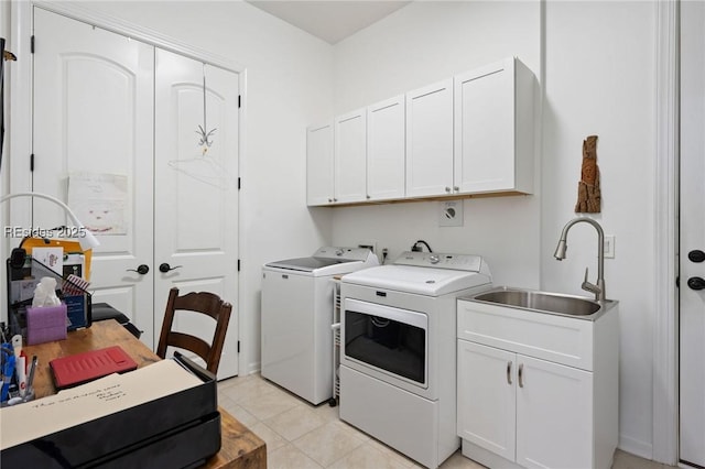 laundry area with sink, light tile patterned floors, cabinets, and independent washer and dryer