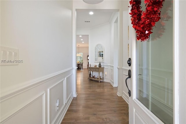 corridor with crown molding and dark wood-type flooring