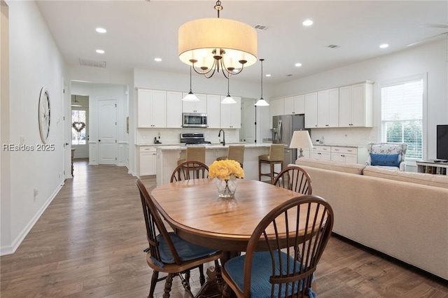 dining space with sink and dark hardwood / wood-style flooring