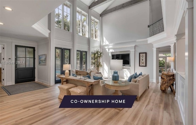 living room with beam ceiling, plenty of natural light, high vaulted ceiling, and light hardwood / wood-style floors