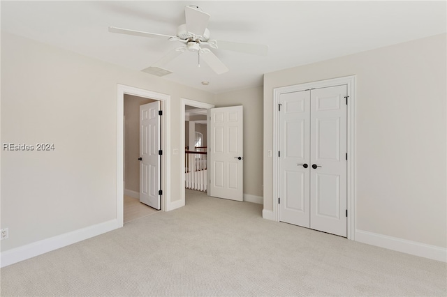 unfurnished bedroom featuring ceiling fan, a closet, and light carpet