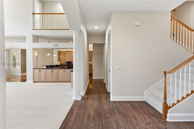 entryway featuring sink, dark hardwood / wood-style flooring, and decorative columns