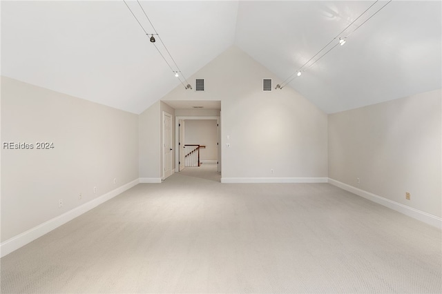 bonus room with vaulted ceiling and light colored carpet