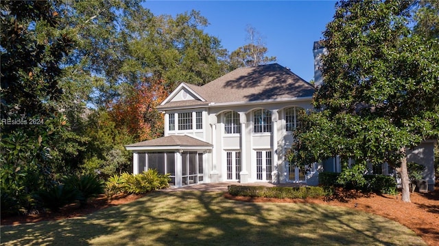 exterior space featuring a front lawn and a sunroom