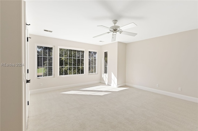 carpeted spare room featuring ceiling fan