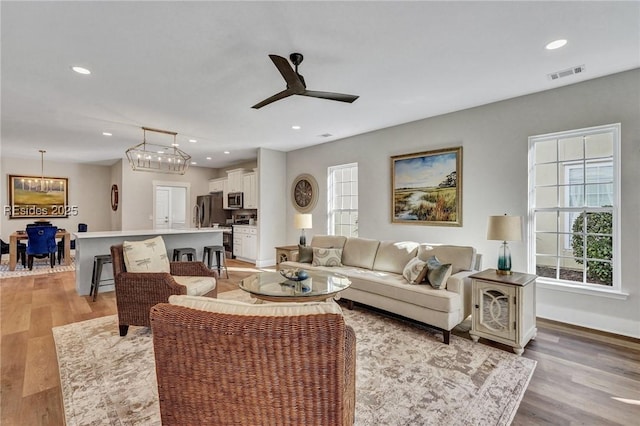 living room with light hardwood / wood-style flooring and ceiling fan