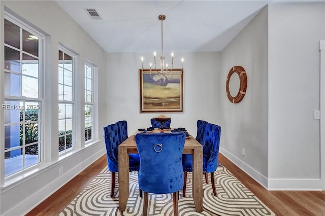 dining space featuring hardwood / wood-style floors and a notable chandelier