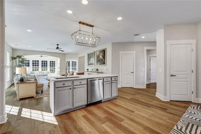 kitchen featuring sink, gray cabinetry, decorative light fixtures, light hardwood / wood-style flooring, and stainless steel dishwasher