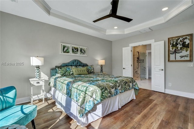 bedroom featuring ceiling fan, ornamental molding, a tray ceiling, and hardwood / wood-style floors