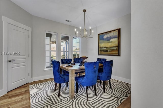 dining space featuring a notable chandelier and light wood-type flooring