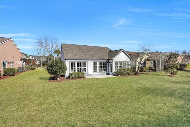 rear view of house featuring cooling unit, a patio, and a lawn