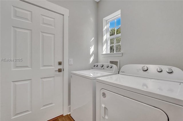 clothes washing area with wood-type flooring and independent washer and dryer