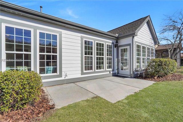 rear view of house featuring a lawn and a patio