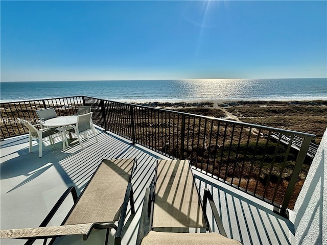 balcony featuring a water view and a beach view