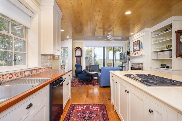 kitchen featuring white cabinetry, black dishwasher, stainless steel gas cooktop, light hardwood / wood-style floors, and wooden ceiling