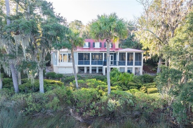 rear view of property featuring a sunroom