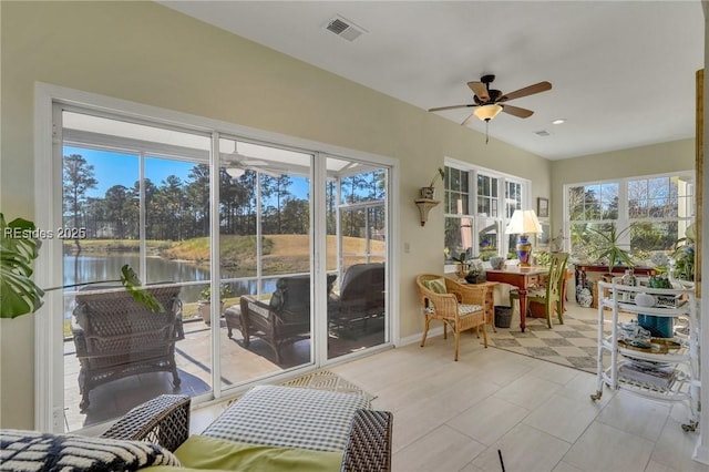 sunroom featuring ceiling fan and a water view