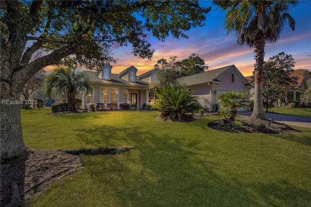 view of front of property with a garage and a yard