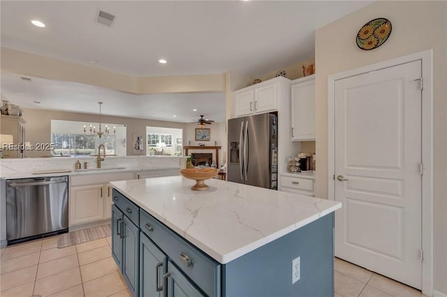 kitchen with blue cabinets, sink, white cabinets, and appliances with stainless steel finishes