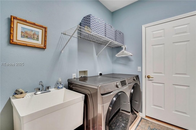 laundry area with washing machine and clothes dryer and sink