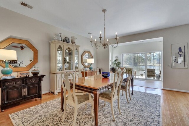 dining area with a notable chandelier and light wood-type flooring