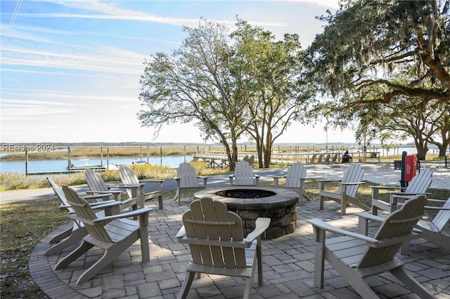 view of patio featuring an outdoor fire pit and a water view