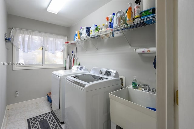 washroom with washing machine and dryer, sink, and light tile patterned floors