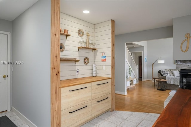 interior space featuring light tile patterned floors and wooden walls