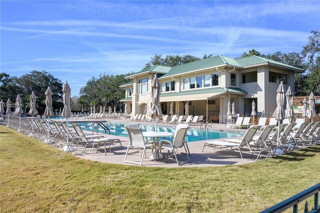 back of house with a lawn, a community pool, and a patio area