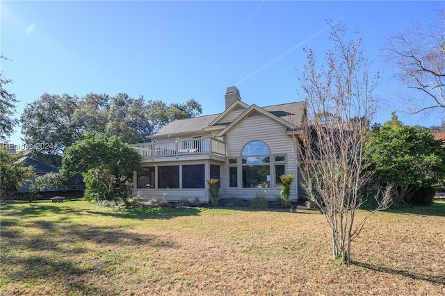 rear view of house with a balcony and a yard