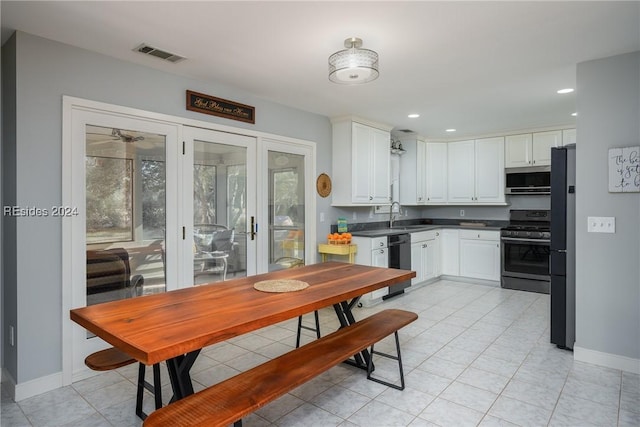 kitchen with stainless steel appliances, white cabinetry, and sink