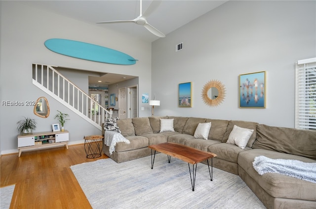 living room featuring hardwood / wood-style flooring, high vaulted ceiling, and ceiling fan