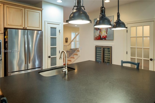 kitchen featuring sink, stainless steel fridge, and light brown cabinetry