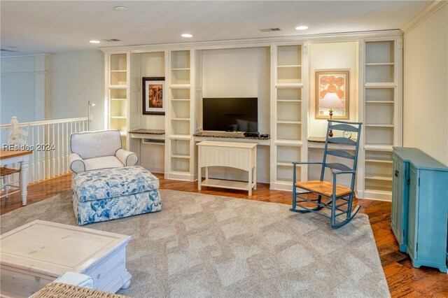 living area with crown molding and hardwood / wood-style floors