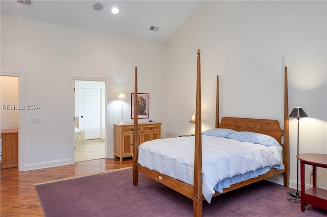 bedroom with vaulted ceiling and hardwood / wood-style floors