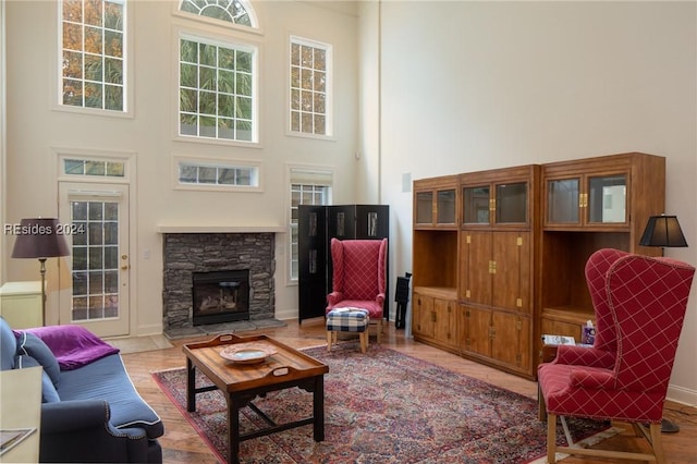 living room with a towering ceiling and a fireplace